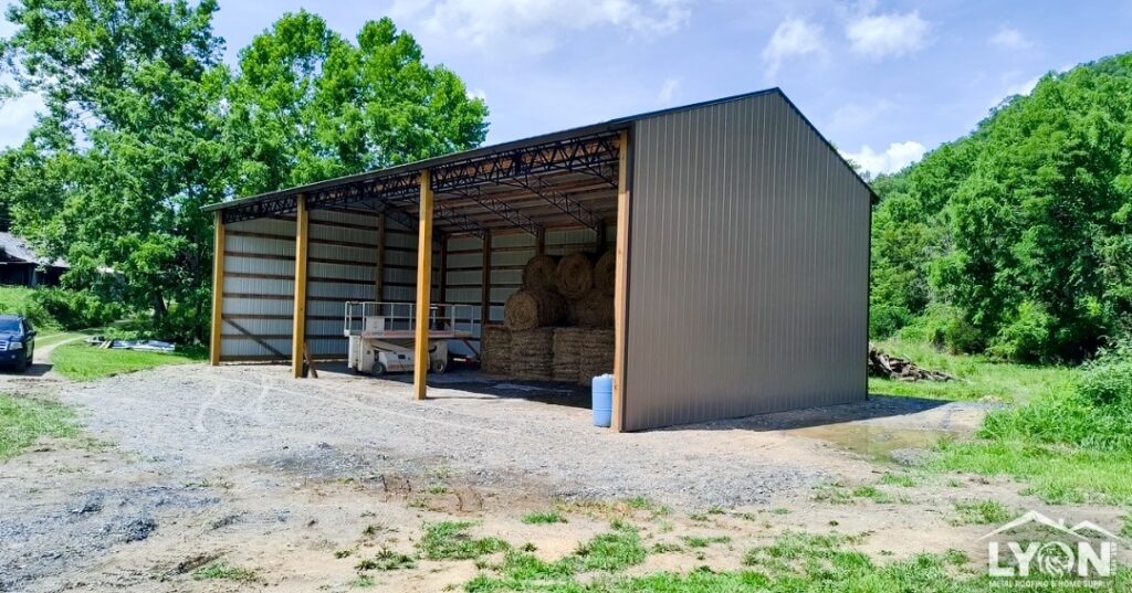 Agricultural pole barn with steel trusses and metal siding used for hay storage and farm equipment protection.